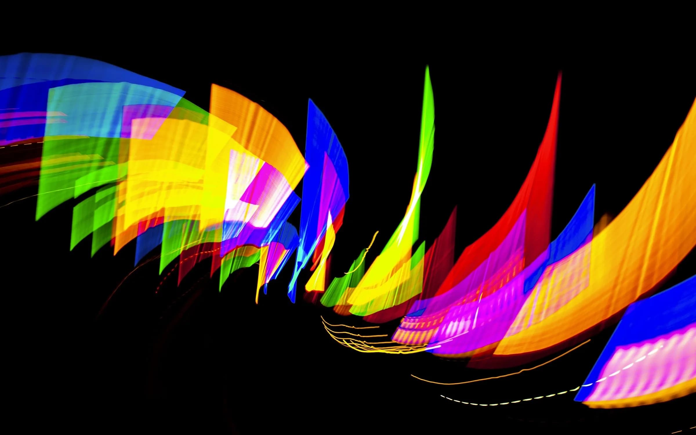 Bright ribbons of blue, yellow, orange and magenta light sweeping across a black background
