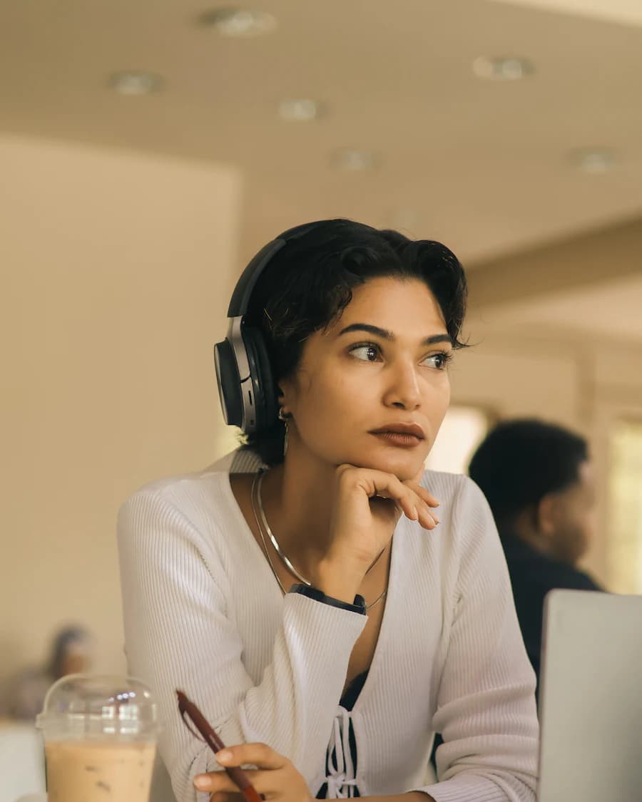 Woman wearing headphones, chin on hand, listening during a call
