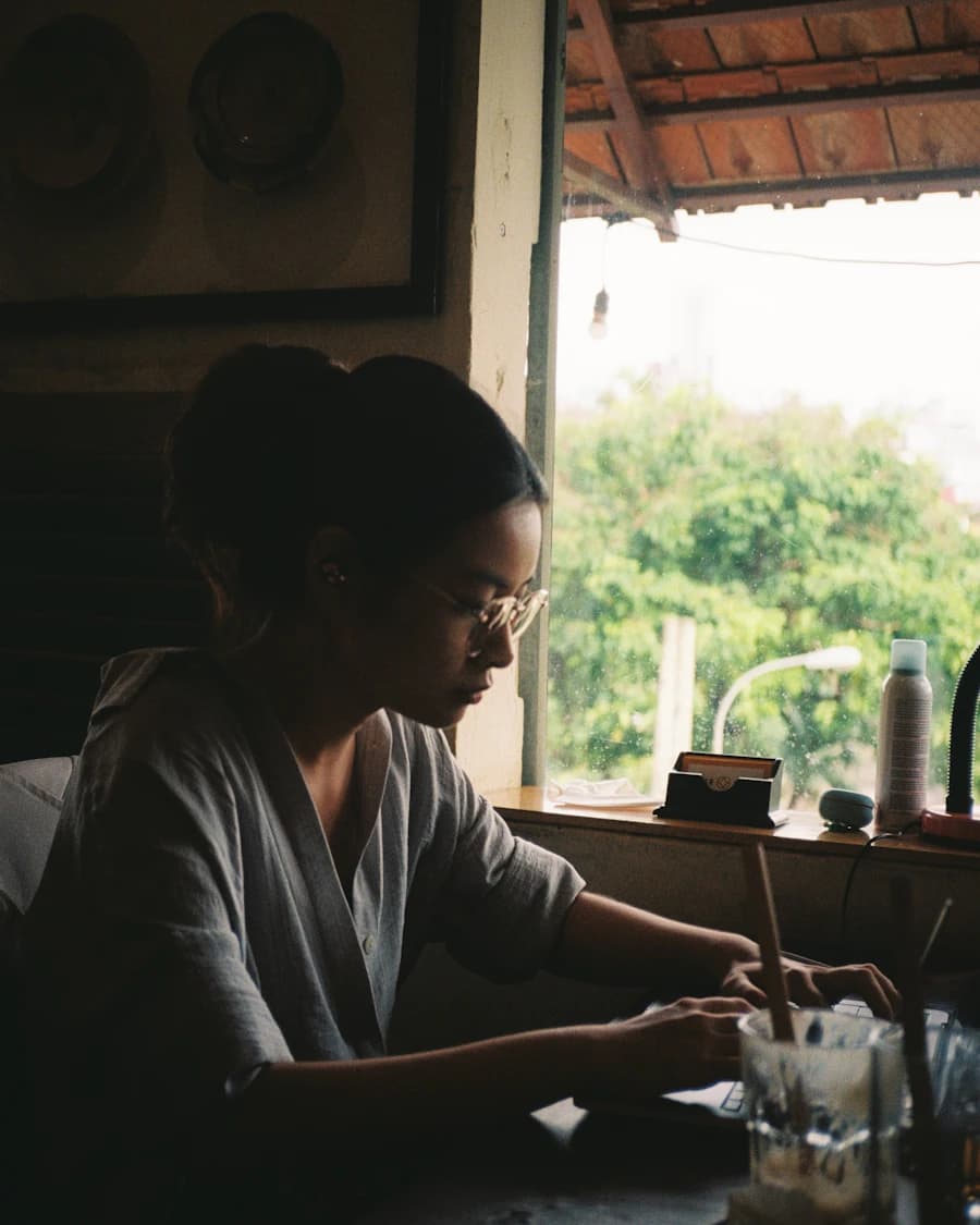 Woman writing at a desk beside an open window